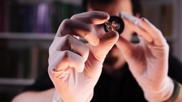 Eigenaar pandjeshuis onderzoekt gouden ring met diamant met vergrootglas — Stockvideo