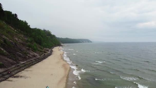 Linha costeira com montanha de um lado e oceano tempestuoso do outro é filmado por drone — Vídeo de Stock