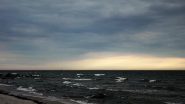 Paisaje del océano junto a la costa de arena en tiempo nublado con olas en la superficie del agua en slow mo — Vídeo de stock