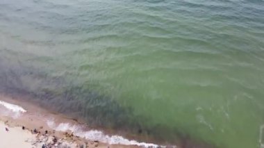 Okyanus dalgalarının kumsalda kırılışını gösteren hava manzarası.