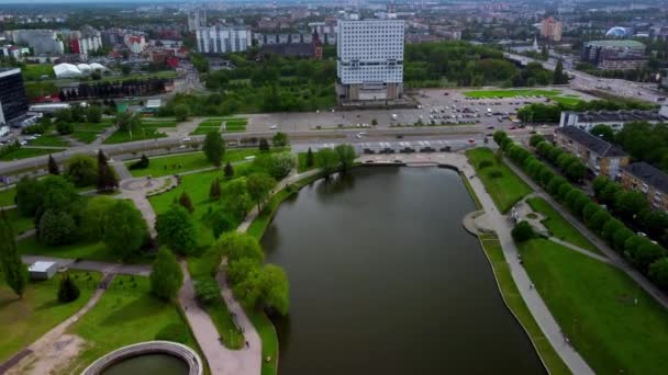 Widok na miasto z drogą pełną samochodów i nowoczesnego budynku stojącego przed kanałem wodnym — Wideo stockowe