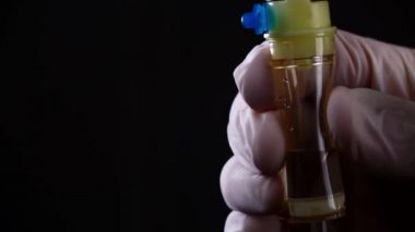 Eldivenli el, siyah arkaplanda yakın plan bir infüzyon sistemini düzenler