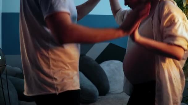 Man och gravid kvinna dansar håller hand i vardagsrummet — Stockvideo