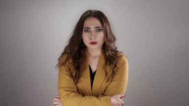 Bir kadın kollarını kavuşturur ve ağır çekimde kötü haberlerle şaşkına döner.