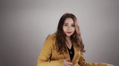 Genç ve çekici bayan dans ediyor ve poz veriyor kameraya beyaz arka planda yavaş çekimde bakıyor.