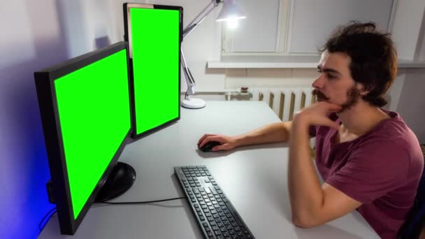 Timelapse του εργαζόμενου προγραμματιστή μπροστά από δύο οθόνες με πράσινη οθόνη και πληκτρολόγηση στο πληκτρολόγιο — Αρχείο Βίντεο