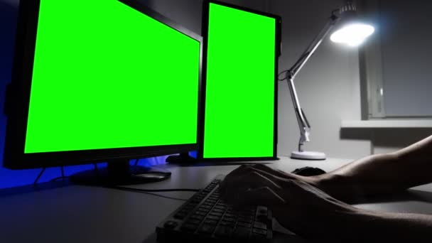 Timelapse di mani uomo digitando su una tastiera di fronte a due monitor con canale alfa di notte — Video Stock