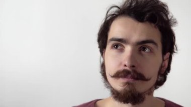 Beyaz arka planda duran bıyıklı genç sakallı adamın izole edilmiş portresi.