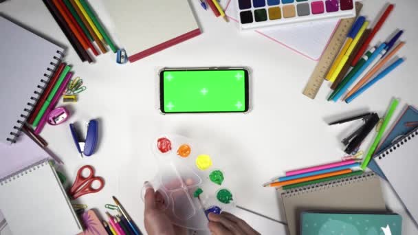 Člověk se učí kreslit pomocí palety s barvami a štětcem sledování online lekce na smartphonu — Stock video