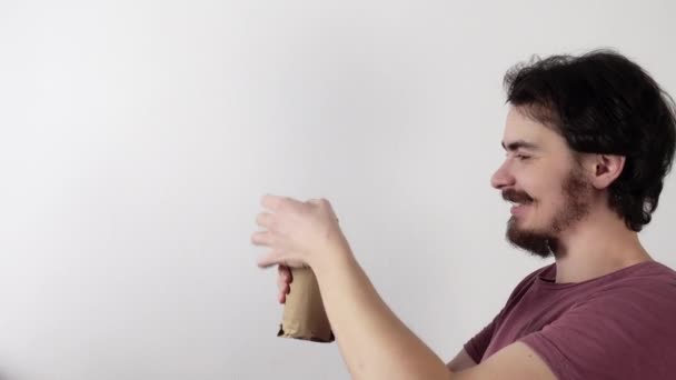 Vista de perfil del joven barbudo abriendo lata de cerveza y luego verterla en un vaso y bebiendo — Vídeos de Stock