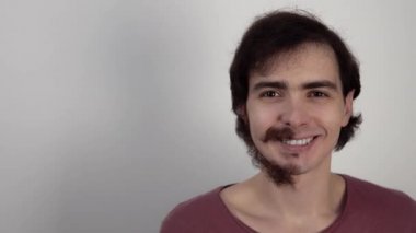 Adam yüzünün bir kısmını baltanın arkasına saklar ve bıyıksız tıraşlı yanaklarını gösterir.