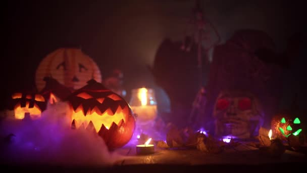 Névoa mística se arrasta entre as abóboras esculpidas assustadoras das decorações de Halloween — Vídeo de Stock