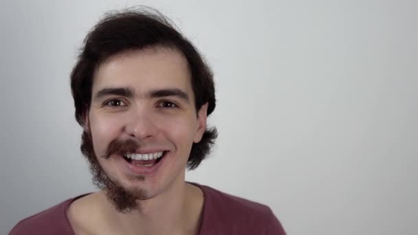 Portret van een gelukkige man die zijn gezicht nog niet geschoren heeft op een witte achtergrond — Stockvideo