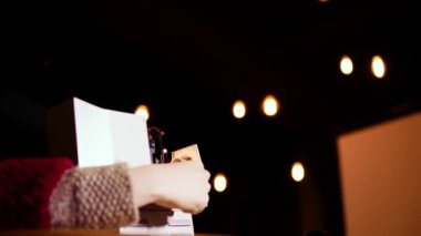 Eski moda slayt projektörü ve genç bir kadın çalışmaya hazırlanmak için fotoğraf filmini ekliyorlar.