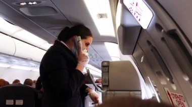 Genç uçuş görevlisi ya da hostes kalkıştan önce güvenlik talimatlarını açıklayacak.