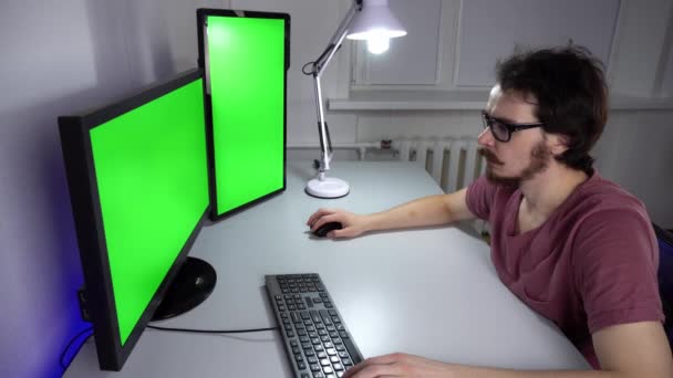 Koncentrált programozó dolgozik a számítógép Chroma billentyűt két monitoron — Stock videók