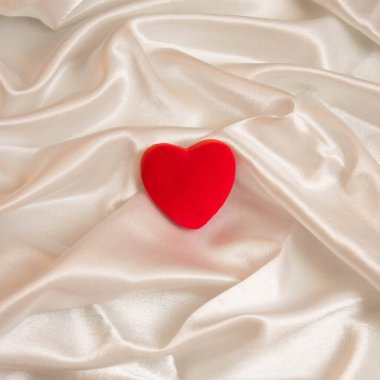 Pastel beyaz arka planda kırmızı bir kalple yapılan Sevgililer Günü minimal kompozisyonu