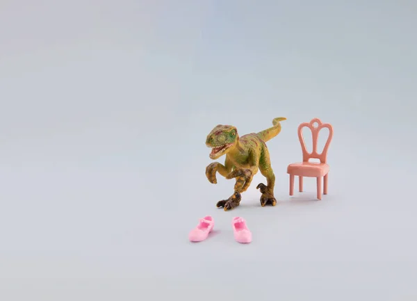 Dinozor oyuncağı pembe ayakkabıları deniyor. Ayakkabı mağazasındaki müşteri yaratıcı kavram.