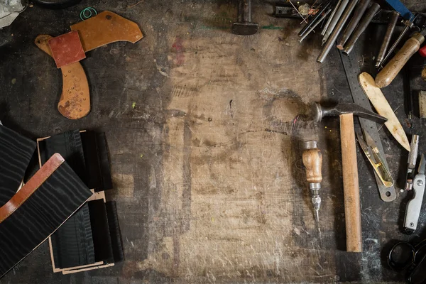 Кожаные ремесленные инструменты на рабочем столе с царапинами — стоковое фото