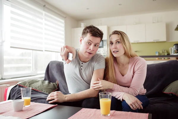Couple enjoying themselves and watching tv on the sofa — Stock Photo, Image