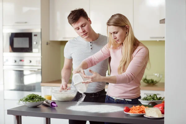 Paar voorbereiding van de pizza in de keuken Stockafbeelding