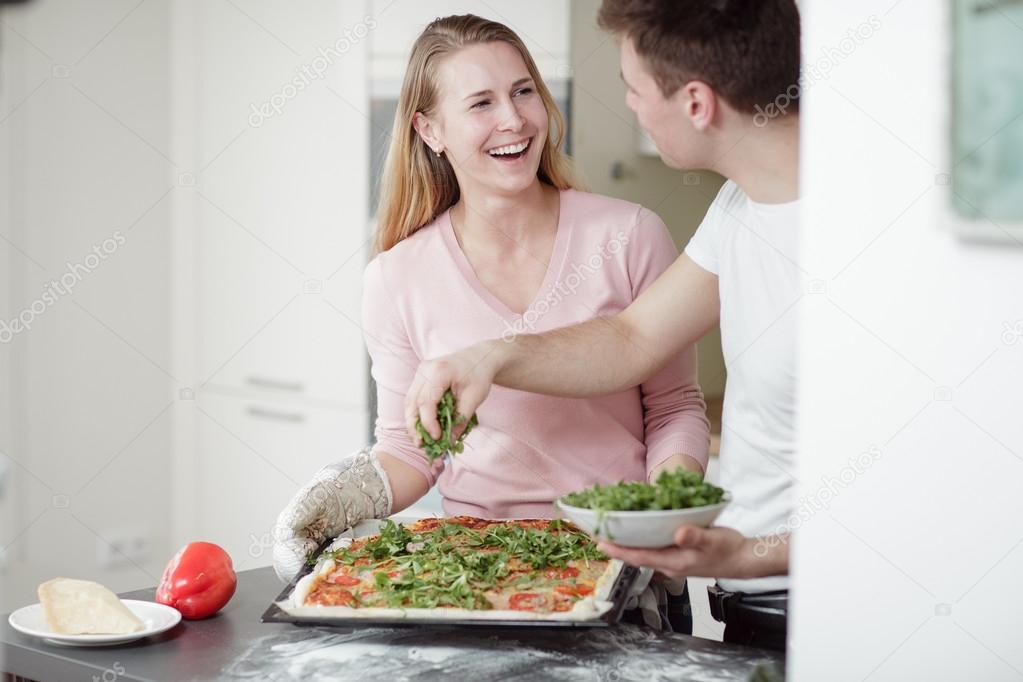 couple preparing the pizza in the kitchen