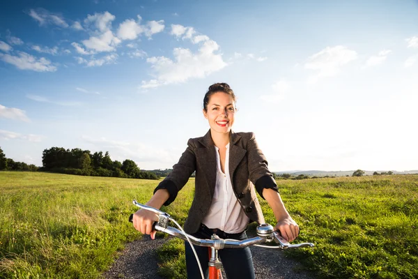 Vrouw op retro oranje fiets — Stockfoto
