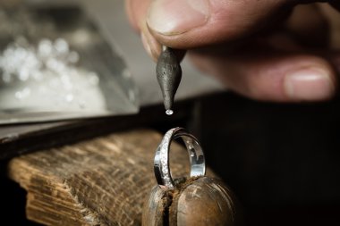 Man Putting diamond on ring clipart