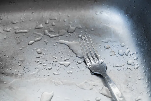 Wet fork  in the kitchen sink — Stock Photo, Image