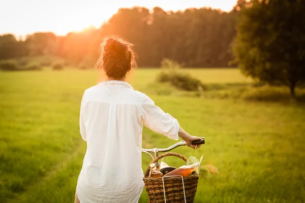 Mulher andar de bicicleta com a cesta — Fotografia de Stock