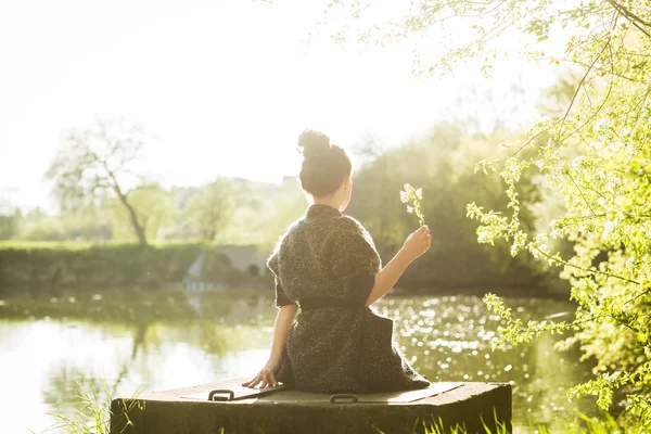 Beautiful black hair woman enjoying blooming tree — Stock Photo, Image