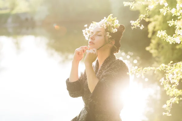 Mulher de cabelo preto bonita apreciando árvore florescente — Fotografia de Stock