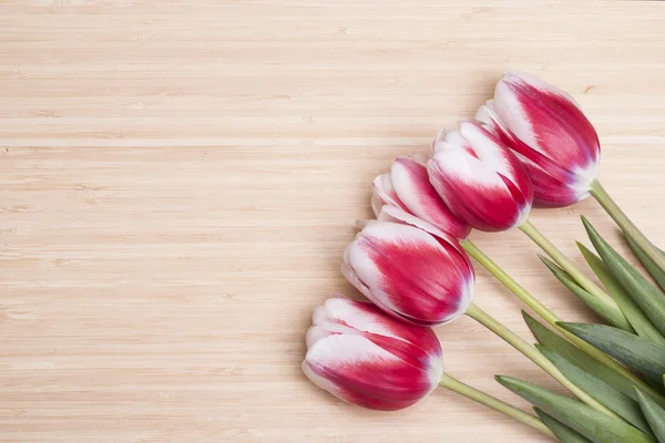 Czerwone tulipany na stole — Zdjęcie stockowe
