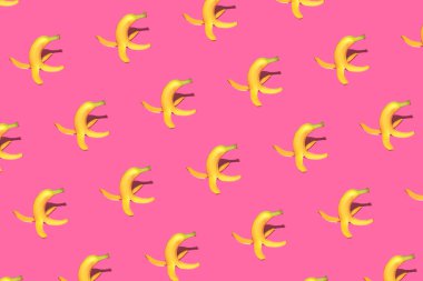 Pembe parlak arkaplanda muz kabuğuyla yaratılmış yaratıcı desen. Eğlenceli ve mutlu bir hayat fikri. Bahar ya da yaz mevsimi konsepti.