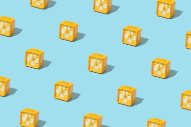 Pastel mavi arka planda parlak hardal sarısı alarm saatiyle yapılmış yaratıcı bir model. Retro estetik stil. Asgari zaman kavramı. Bahar ya da yaz güneşli planlar.