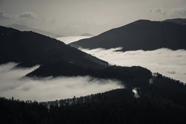 Mysterious black mountain emerging from the clouds