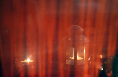 Üç farklı şekilli mum çubuğu ve yanan mumlar kahverengi çizgili yüzeyden yansıyor. Anma törenleri, ruhanilik ve tefekkür zamanı