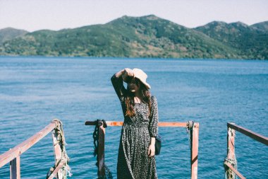 Denizin önünde hasır şapkalı bir Japon kadın.