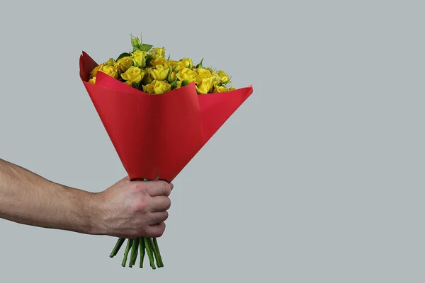 Rosas Amarelas Embalagens Vermelhas Fundo Cinza São Realizadas Mão Homem — Fotografia de Stock