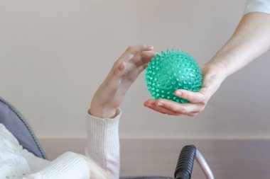 Serebral felçli çocuklar, egzersiz ve masaj yeşil topları. Çocuk, topu bir gönüllünün elinden almaya çalışır. Seçici bir şekilde odaklanır.