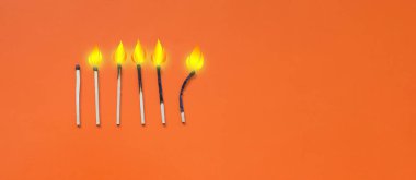 Parlak turuncu arkaplanda yanan kibritler grubu