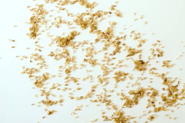 Beyaz bir yüzeye dağılmış bulgur gevreğinin doğal taneleri.