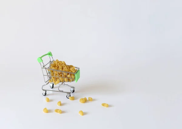 Verkaufs- und Einkaufskonzept, Pasta wird in einen kleinen Warenkorb gegossen — Stockfoto