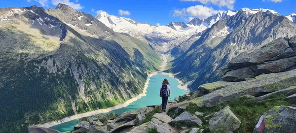 Egy lány túrázik az Olperer kunyhó felé, ahonnan csodálatos kilátás nyílik a Schlegeis Alpesi-tóra a Zillertal völgyben, Osztrák Alpokban — Stock Fotó