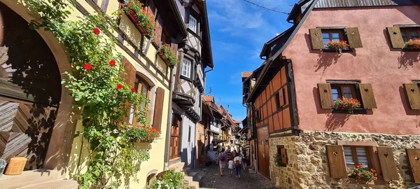 Rua estreita forrada com casas de madeira em Eguisheim, Alsácia, França — Fotografia de Stock