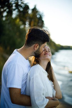 Genç sakallı bir adam gün batımında parkta ya da ormanda beyaz elbiseli genç bir kadını nazikçe öper. Birbirine aşık çiftler. Aşk hikayesi