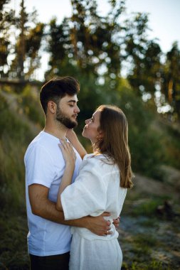 Beyaz elbiseli genç çift gün batımında parkta ya da ormanda birbirlerine nazikçe sarılıp bakıyorlar. Birbirine aşık çiftler. Aşk hikayesi