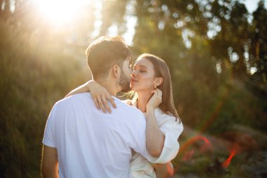 Genç sakallı bir adam gün batımında parkta ya da ormanda beyaz elbiseli genç bir kadını nazikçe öper. Birbirine aşık çiftler. Aşk hikayesi