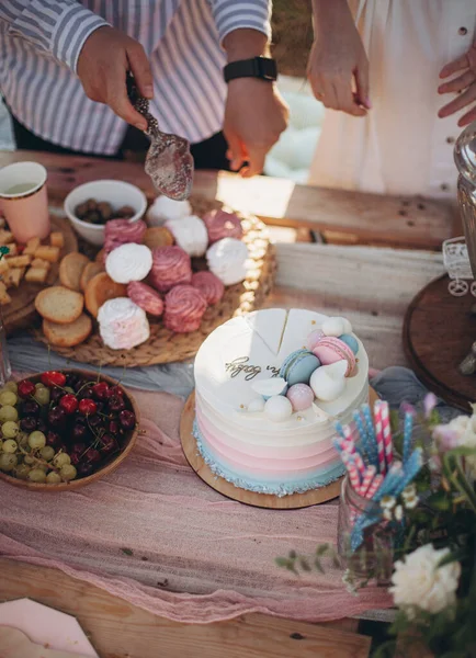 man is about to take a piece of cake. a man is going to treat him with a birthday cake. the main dessert of the holiday. birthday cake