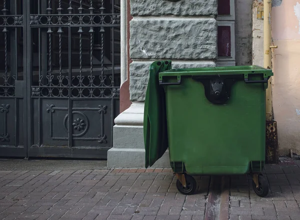 Grüner Müllcontainer Auf Der Straße Müllcontainer Der Nähe Des Hauses lizenzfreie Stockfotos